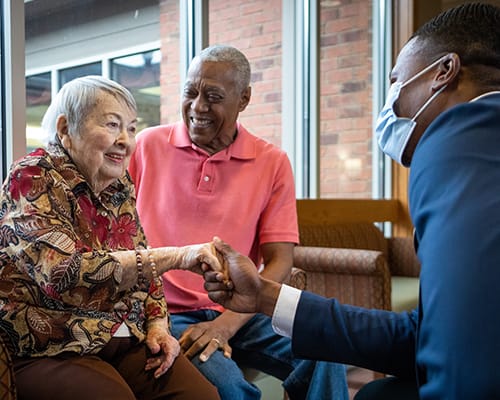 caregiver and resident shaking hands